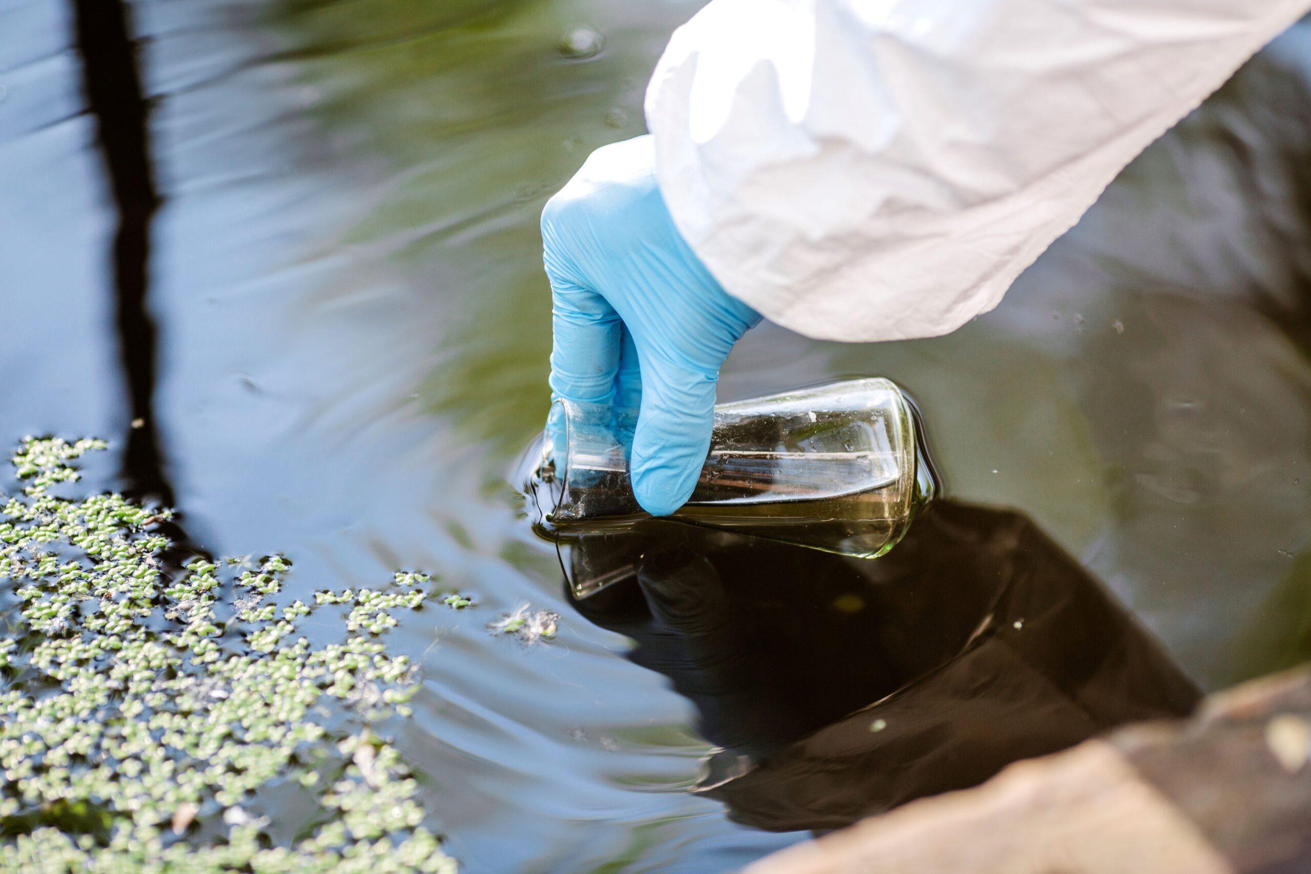 Eine Person kontrolliert die Wasser Werte aus einer Abwassergrube 